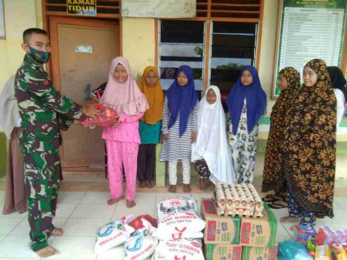 Pratu Budi Julianto diabadikan saat menyalurkan bantuan sembako di panti asuhan putri Alwasliyah Padang Matinggi. 