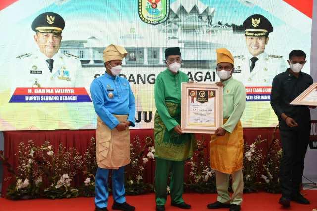 Bupati Sergai H Darma Wijaya didampingi Wabup H Adlin Umar Yusri Tambunan saat menyerahkan piagam penghargaan kepada Tengku Erry Nuradi.