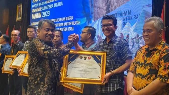 Kepala Bagian Hukum Setdakab Tapanuli Utara, Welly Simanjuntak, menerima penghargaan untuk Bupati Tapanuli Utara 