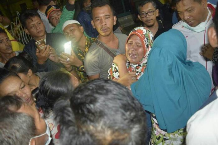 Ayu (berkerudung) histeris menyambut kedatangan jenazah di Pelabuhan Sibolga, Senin (12/2/2018).