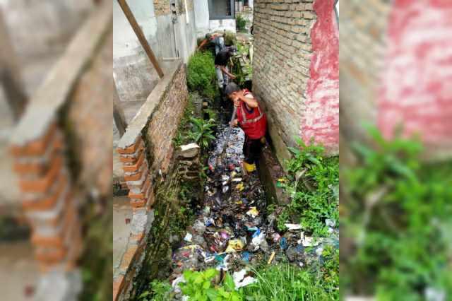 Petugas kembali membersihkan parit dari sampah yang dibuang masyarakat