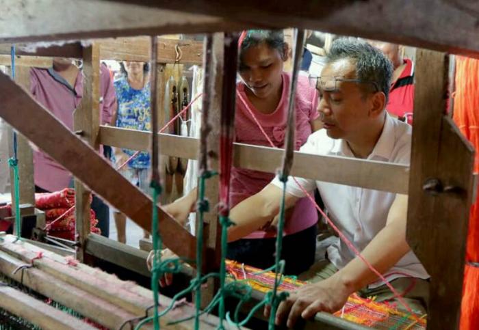 Calon Wakil Gubernur Sumatera Utara, Sihar Sitorus mencoba alat tenun tradisional dalam kunjungannya ke pabrik tenun romauli, Siantar, Rabu (21/3/18).