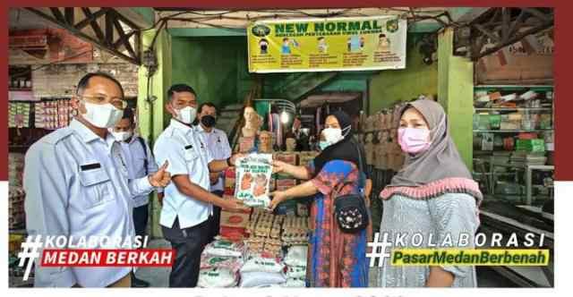 Suwarno Dirut PUD Pasar Medan saat menyerahkan bantuan kepada pedagang.