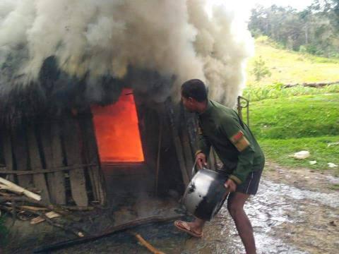 Prajurit TNI membantu memadamkan api