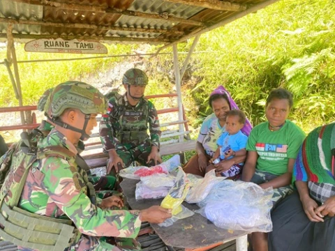 Personel Pos berbagi kasih dengan membagikan baju