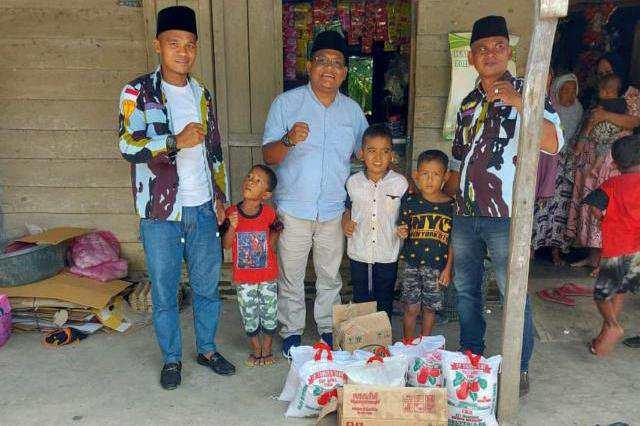 Ketua PAC IPK Simangambat Akhiruddin Ritonga bersama pengurus lainnya menyerahkan secara simbolis bantuan sembako kepada warga.