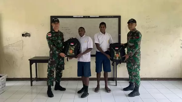 Prajurit TNI membagikan tas sekolah dan alat tulis kepada siswa di Papua 