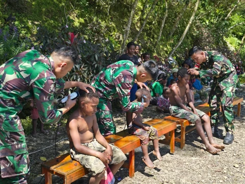 Satgas Pamtas Kewilayahan Yonif 715/Motuliato memberikan pelayanan cukur rambut gratis