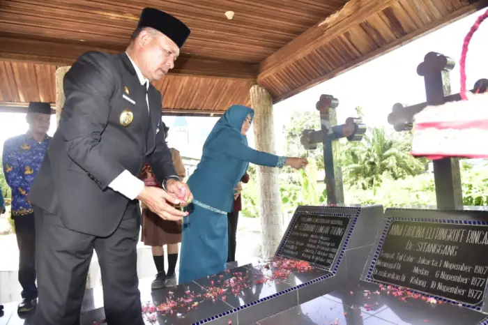 Wakil Bupati Tapanuli Tengah Mahmud Efendi Lubis didampingi Staf Ahli I TP PKK Tapteng Masnoni Mahmud Efendi Lubis, menabur bunga di makan Pahlawan Nasional di Kolang.