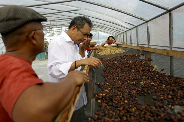 Sihar Sitorus berbincang dengan pemilik  Poda Coffee, Samuel Sihombing di gudang kopi miliknya di Kampung Hutatika Kecamatan Sitinjo, Kabupaten Dairi, Sabtu (2/6/2018).