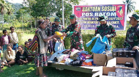Personil Pos Batom membagikan pakaian layak pakai
