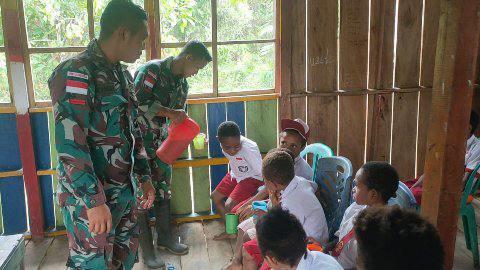 Prajurit TNI memberikan susu pada anak-anak SD di perbatasan Papua 
