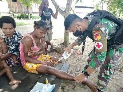Prajurit TNI Satgas Pamtas RI-PNG Yonif 711/Rks memberikan layanan kesehatan