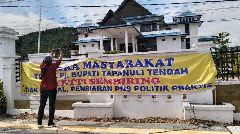Massa membentangkan spanduk isi tuntutan di DPRD Tapteng, Kamis (30/6)