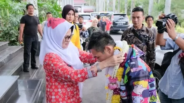 Wali Kota mengalungkan bunga kepada Jon Saragih 