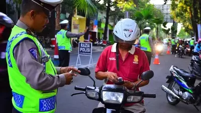 Polisi memeriksa surat kelengkapan kendaraan bermotor saat razia.