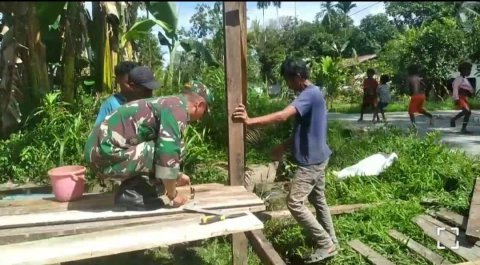Koptu Redemtus Riyanto bersama-sama dengan warga bergotong royong membantu pembuatan rumah