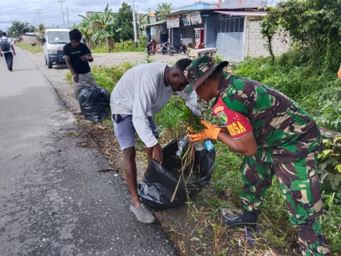 Serma H.H. Butar Butar melaksanakan pembersihan lingkungan bersama masyarakat setempat di Jl. Busiri Ujung
