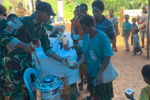 Prajurit TNI bersama warga menikmati bakso dalam suasana penuh keakraban dan kekeluargaan