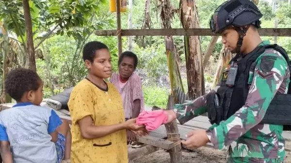 Prajurit TNI membagikan bantuan pakaian di Kampung Yuwainda, Distrik Waris, Kab. Keerom, Papua, Minggu (16/7/2023).
