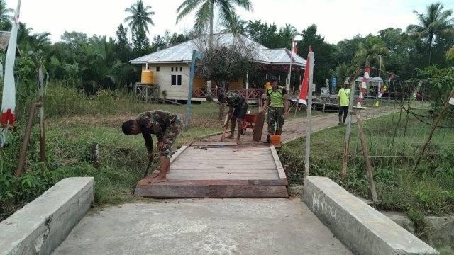 Prajurit TNI dari Satgas TMMD Reguler ke-114 Kodim 1710/Mimika juga menyempatkan diri untuk membantu warga sekitar dalam perbaikan jembatan yang mulai rusak