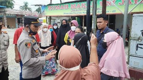 Kapolsek Binjai Timur AKP Arifin Pardede, saat berdialog dengan emak emak yang akan mencabut plank Ormas IPK, Senin (1/8).