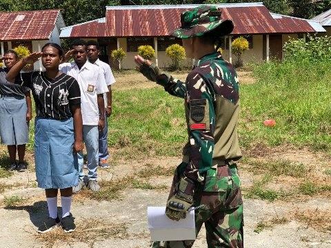 Satgas Pamtas RI-PNG Yonif 126/KC Pos Kalibom mengajarkan tata cara Peraturan Baris Berbaris (PBB) dan formasi pengibaran bendera