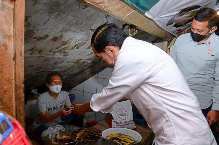 Jokowi membagikan bantuan kepada masyarakat dan pedagang di Pasar Cicaheum, Minggu (28/8). 