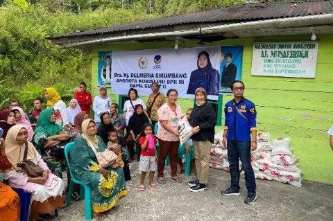 Penyerahan bantuan Sembako oleh Anggota DPR RI, Hj. Delmeria Sikumbang, di Sitahuis.