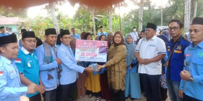 Hj Delmeria Sikumbang menyerahkan bantuan modal usaha budi daya ikan lele kepada Ketua DPD BKPRMI Tapteng Erman Sakti Hutabarat.