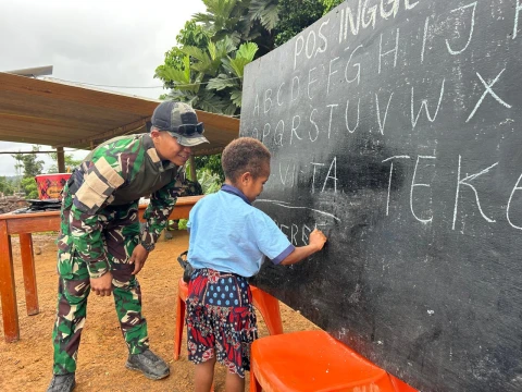 Prajurit TNI mengajar anak-anak di wilayah tersebut Bahasa Indonesia yang baik dan benar. 