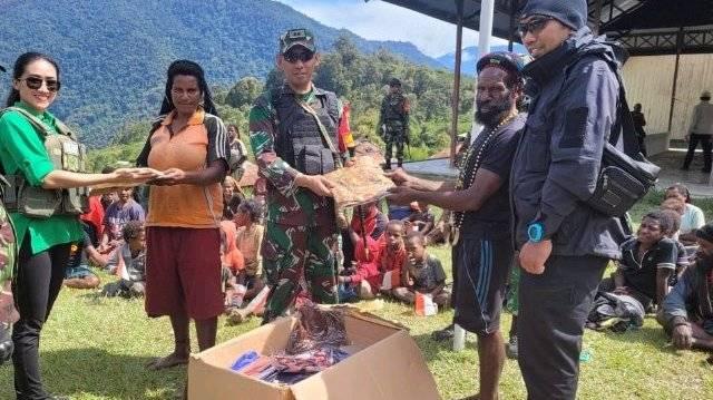 Dandim dan Ketua Persit KCK Cabang XLI Kodim 1714/PJ menyerahkan bantuan sosial kepada masyarakat Yambi