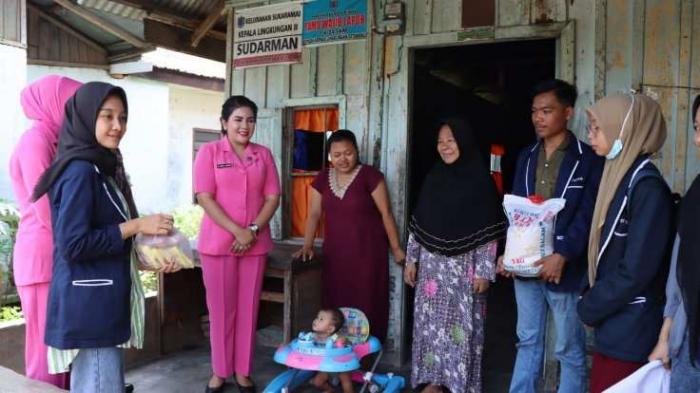 Ketua Bhayangkari Cabang Binjai Ny. Junika Ferio Sano Ginting, beserta pengurus dan Mahasiswa, berbagi dengan warga setempat 