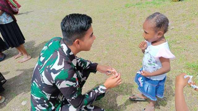 Satgas Pamtas Yonif Raider 142/KJ membagikan permen gula-gula kepada anak-anak gereja