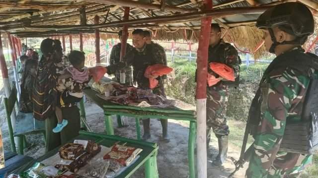 Personel Satgas Yonif Mekanis 203/AK dari Pos Tima membeli berbagai macam sayur-sayuran serta buah-buahan