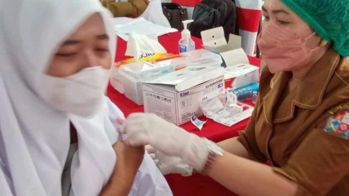 Seorang Nakes Pemkab Deli Serdang menyuntikkan vaksin Covid-19 kepada pelajar, Senin (13/9/2021).