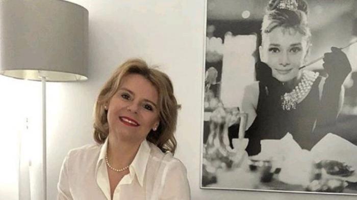 Ilustrasi seorang wanita di depan potret dirinya 