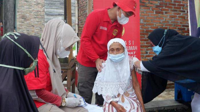 Tenaga kesehatan vaksin nenek lansia warga kelurahan Gunting Saga, Labuhanbatu Utara, Rabu (24/11).