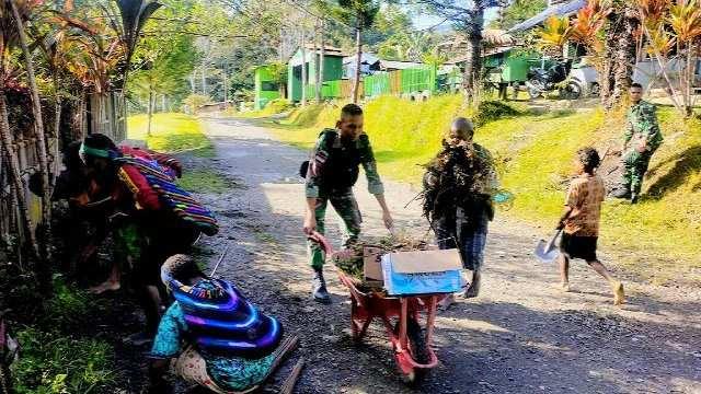 Prajurit TNI bersama masyarakat melaksanakan kerja bakti pembersihan jalan