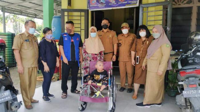 Ahmad Fauzi (9) duduk di kursi barunya diabadikan bersama Koordinator Kemanusiaan YSKI drg Annita, Pdt Indra Buana Hutauruk, Lurah Sidomulyo R. Salomo.