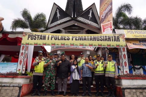 dr Susanti menyerahkan bingkisan kepada petugas Pos Pam dan Pos Yan.